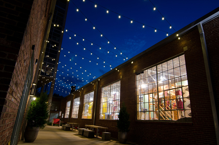 charlotte outdoor string lighting between brick buildings