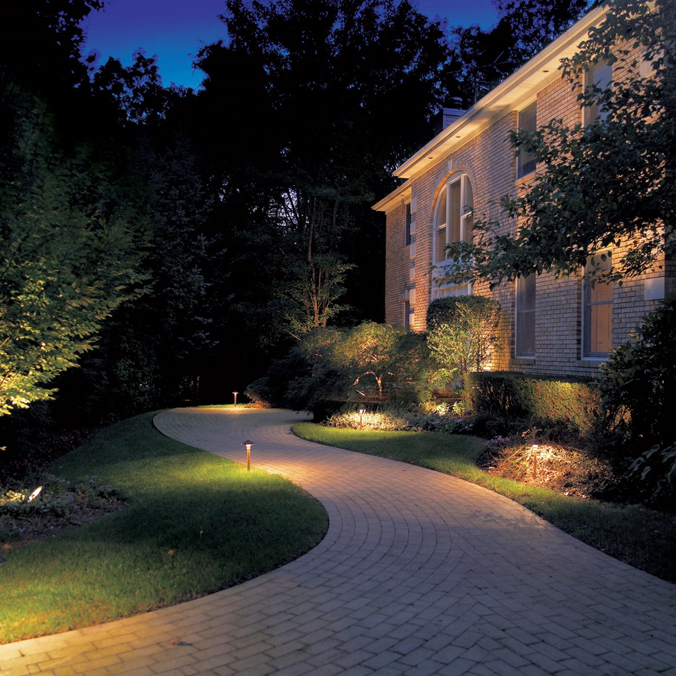 path a long the side of a brick house lit by OLP lighting 