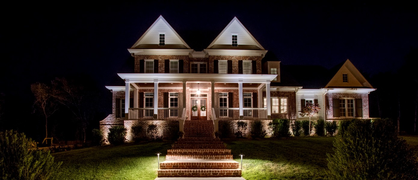 craftsmen style home with wrap around porch and pathway lighting
