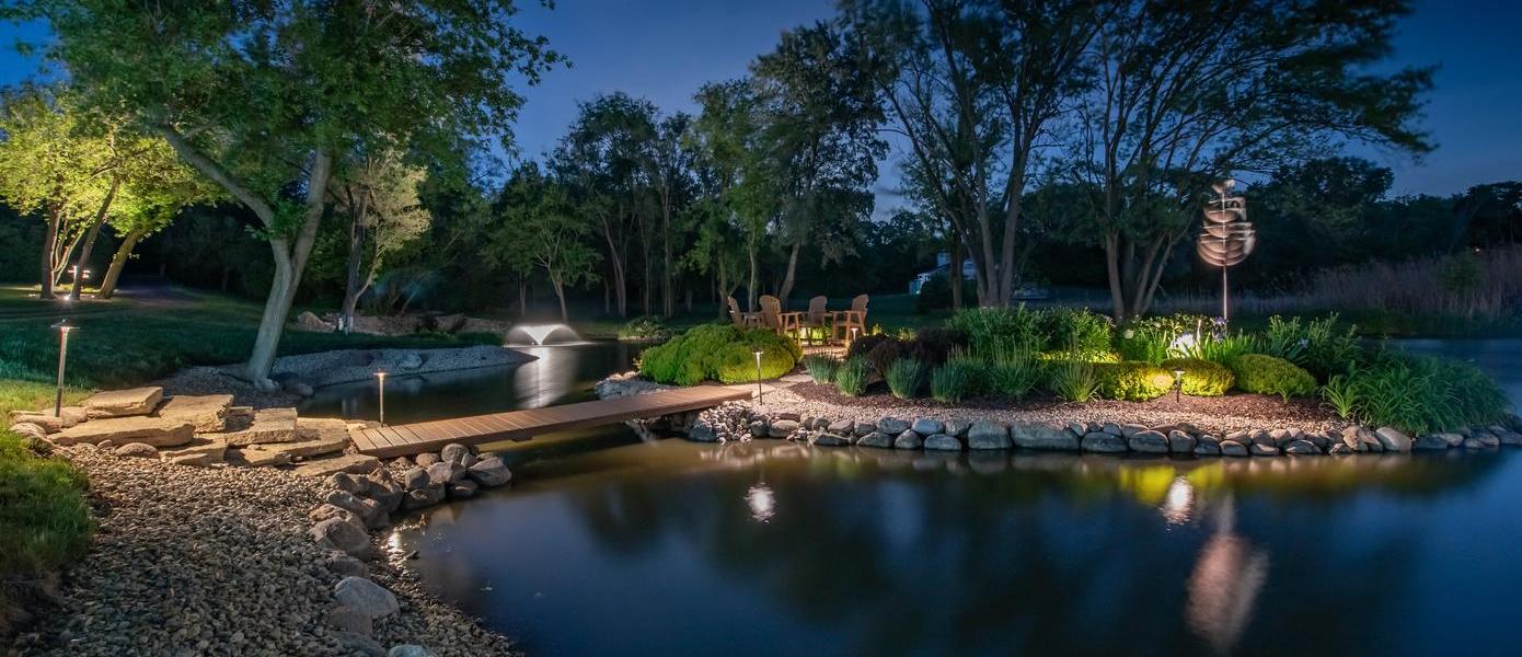 pond with small bridge, plants and landscape lighting