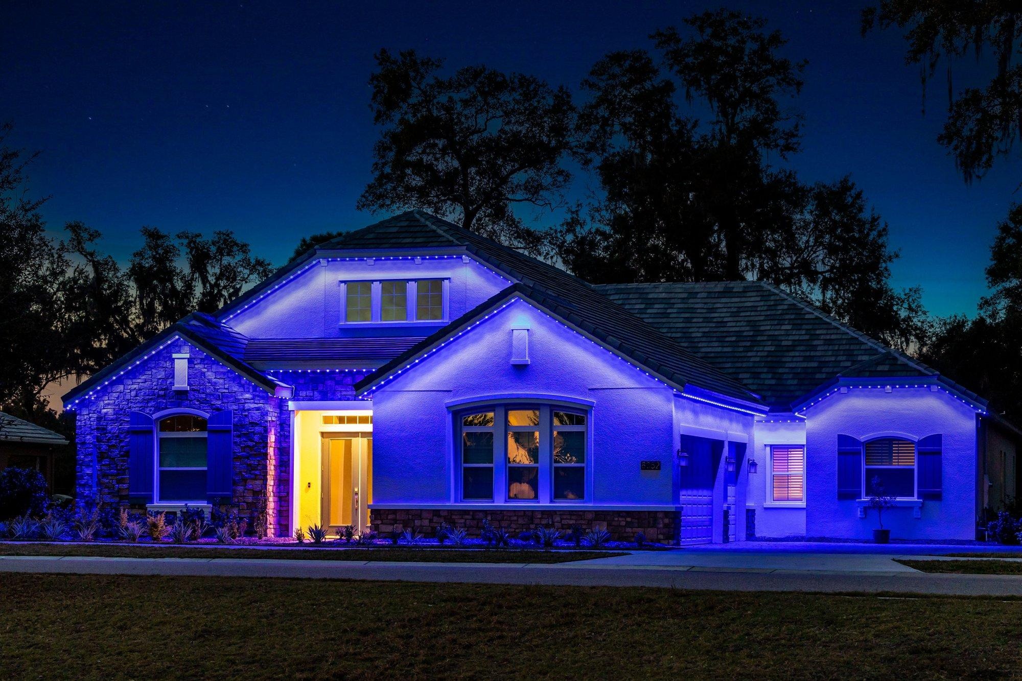 The same craftsman home glowing in rich blue permanent lighting, perfect for Hanukkah or game day