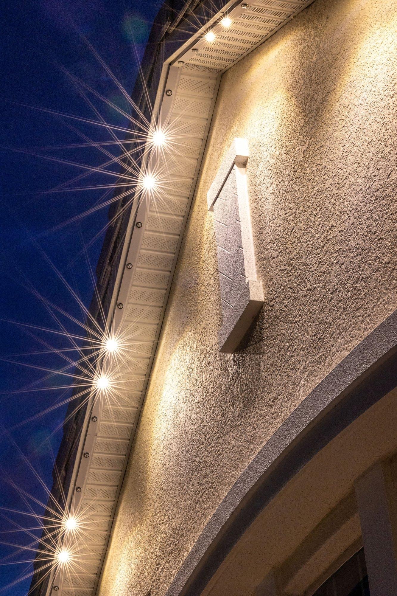 Close-up of warm white permanent lighting set discreetly into a home’s eave