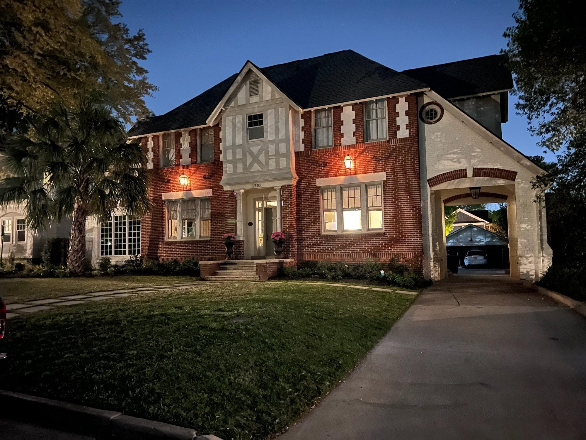 Classic brick Columbia home glowing with warm white architectural and landscape lighting at dusk
