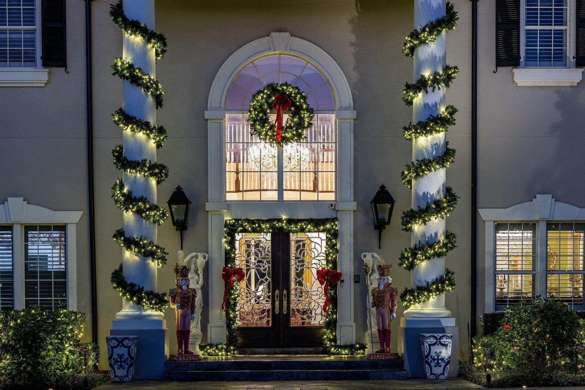 Lit garland-wrapped columns and a wreath framing a grand Orlando entryway