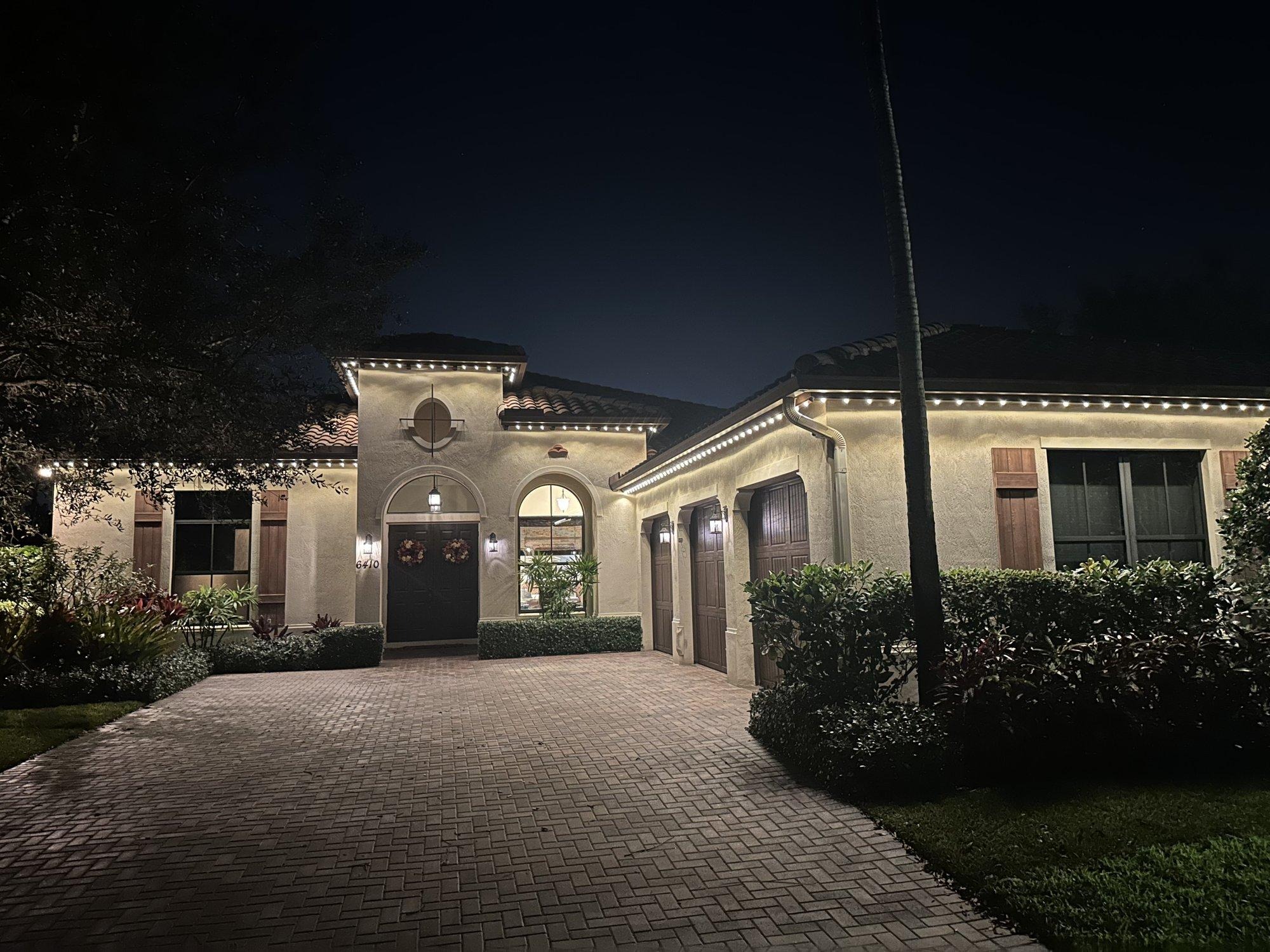 Mediterranean-style West Palm Beach home with elegant warm white roofline lighting