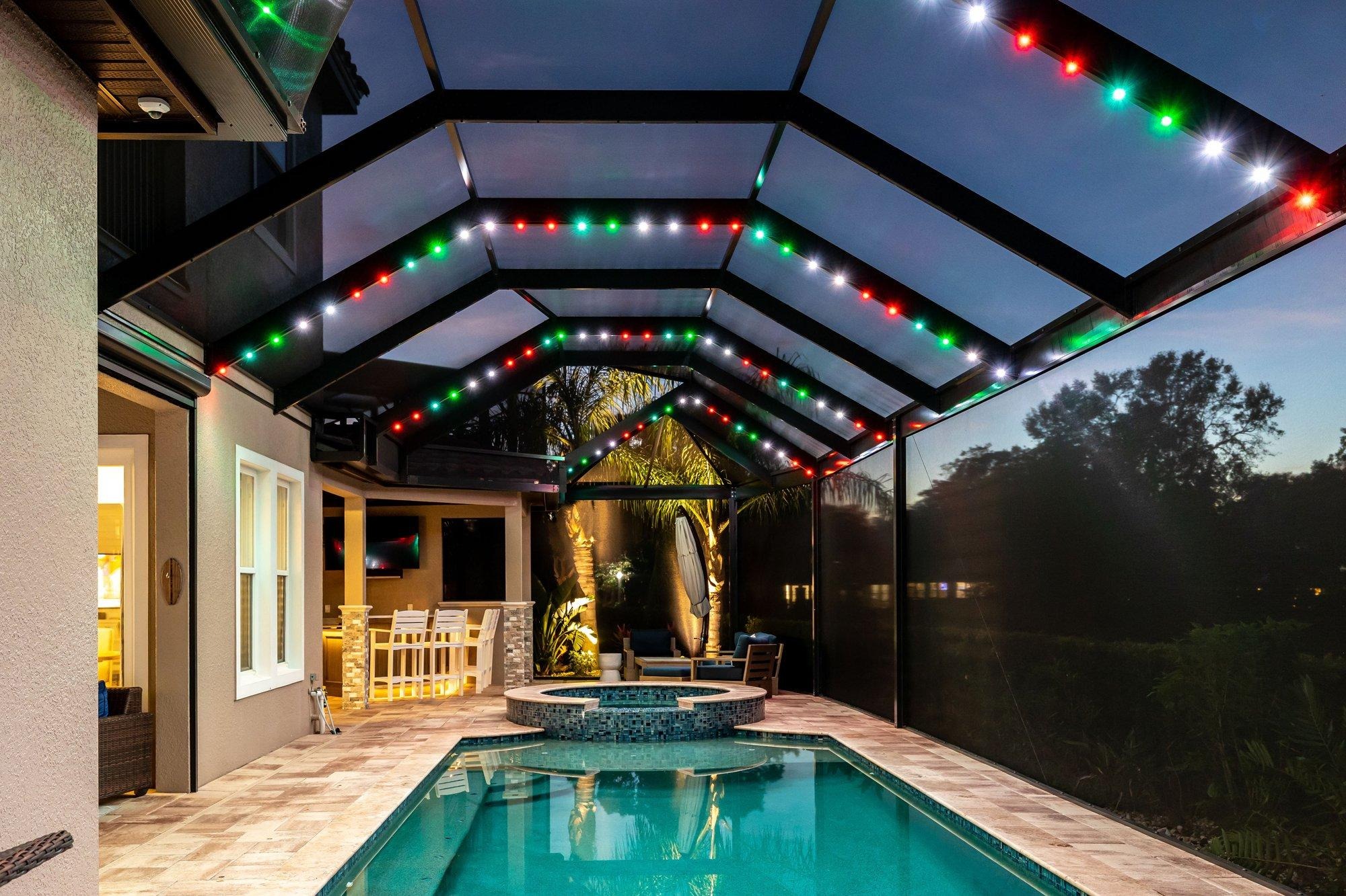 Pool lanai glowing in red, green, and white holiday lighting