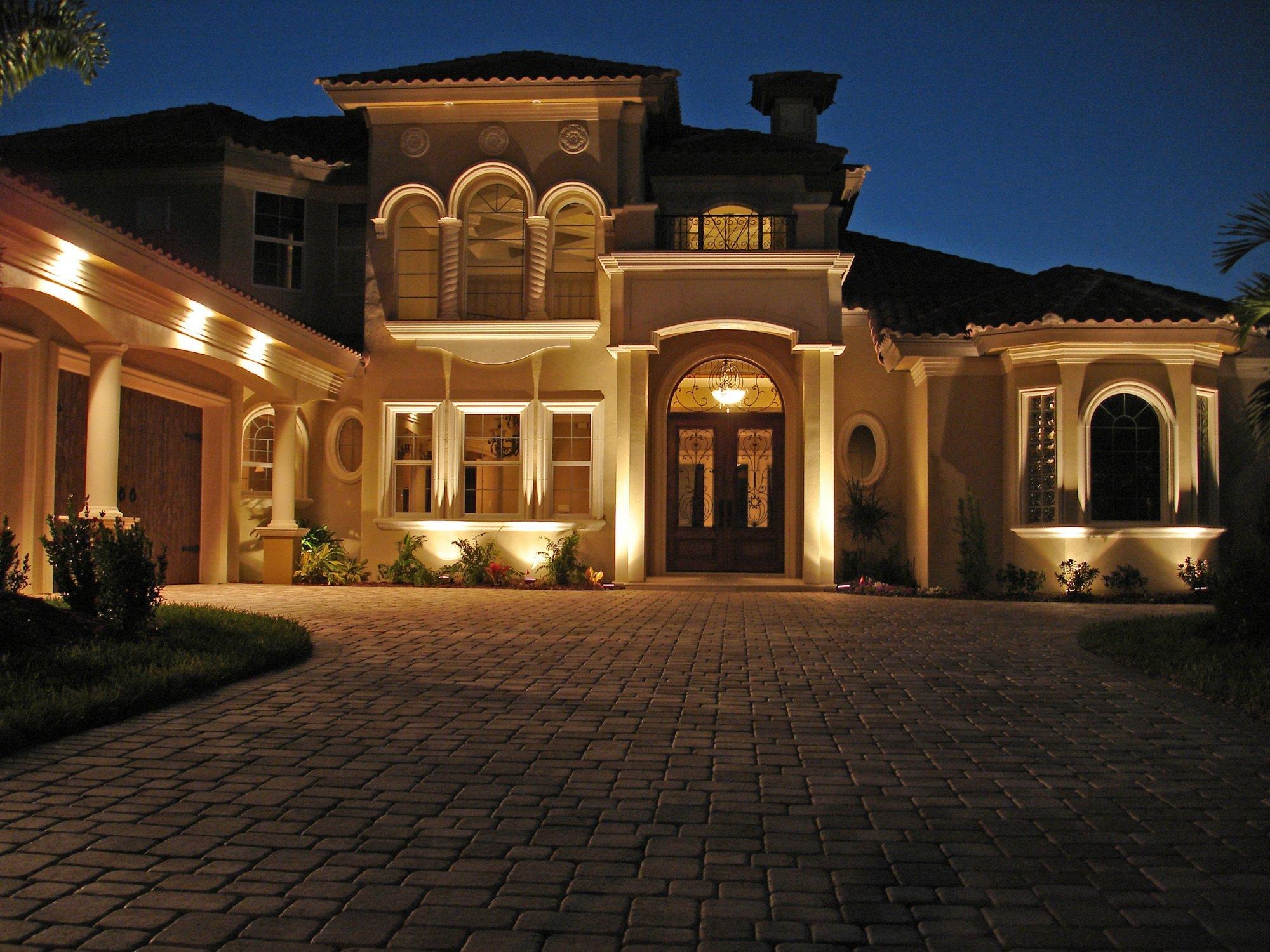 Grand Mediterranean estate illuminated with warm architectural and landscape lighting at dusk