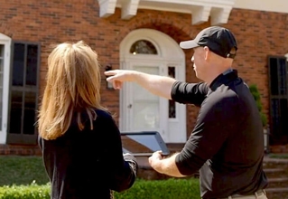 Employ pointing at a house talking with a client