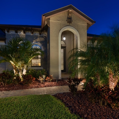 Landscape lighting on the palm trees at this home in Apollo Beach, FL adds curb appeal and safety fo Photo