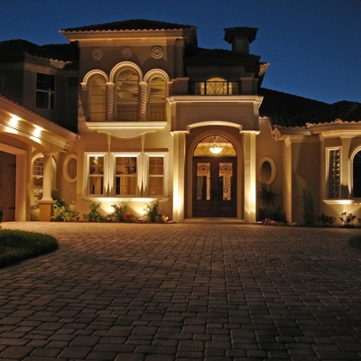 Curb appeal lighting highlights architectural features on this Florida home.  Photo