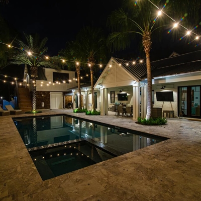 Add bistro lighting over your pool in South Miami.   Photo
