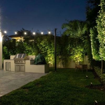 Transform your Miami backyard with bistro lighting and landscape lighting.  Photo