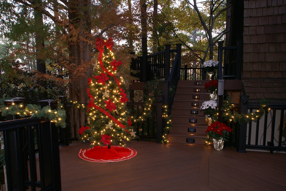 Christmas tree on a deck outside of a home