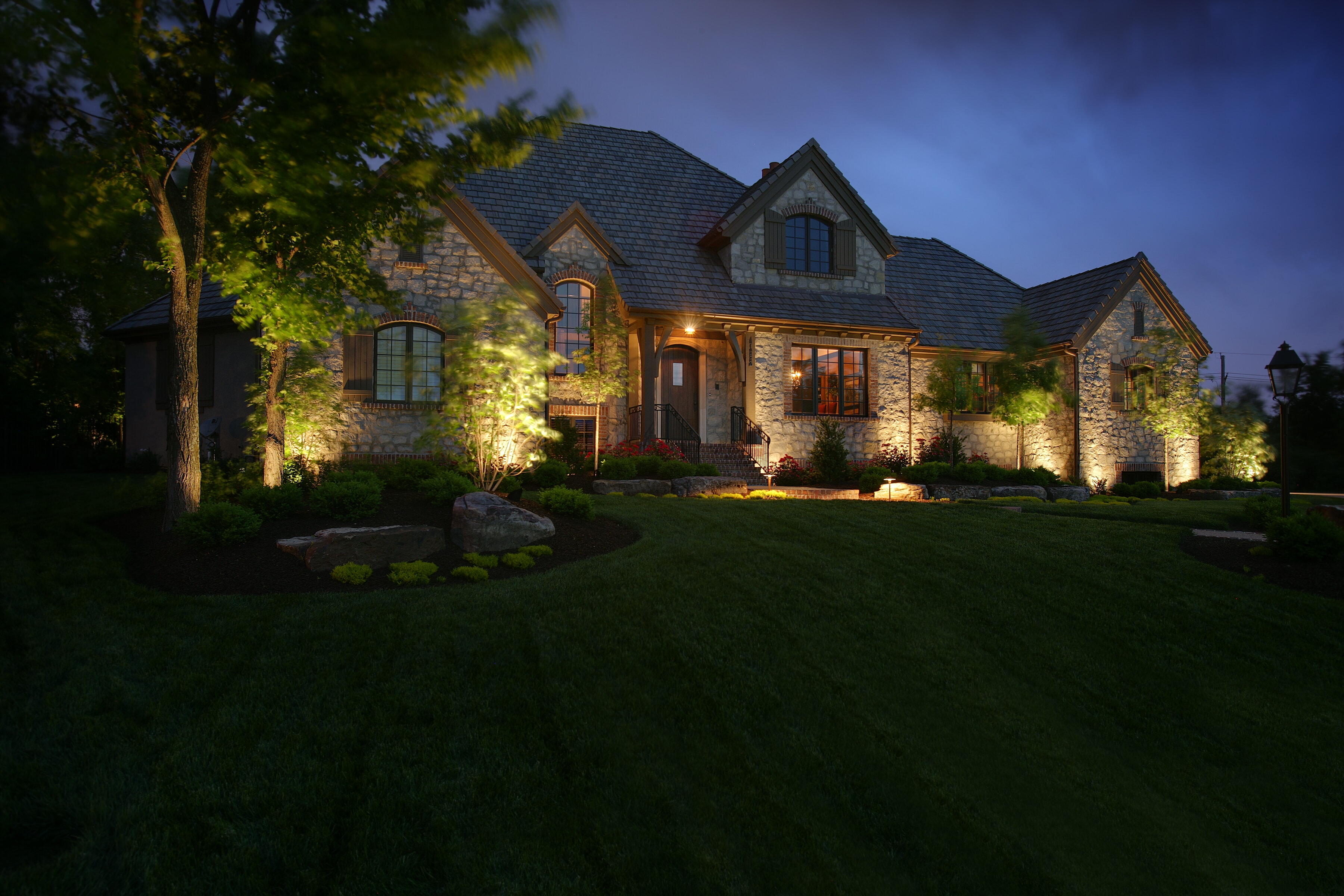 House with Green Lawn and Up Lighting Accents