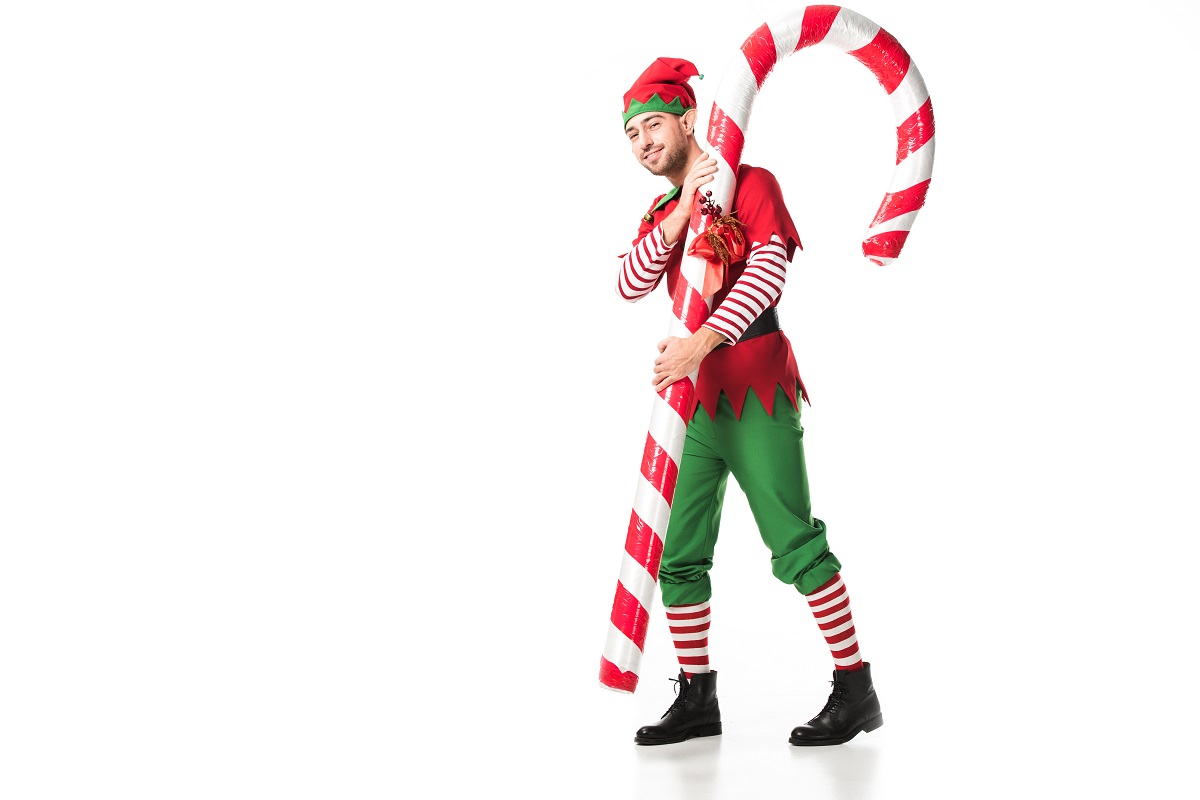 An elf holding a life size candy cane