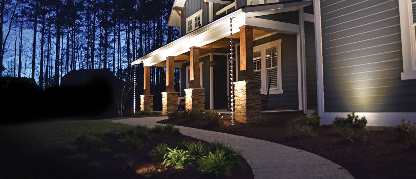 front porch with stone and wood pillars lit at night