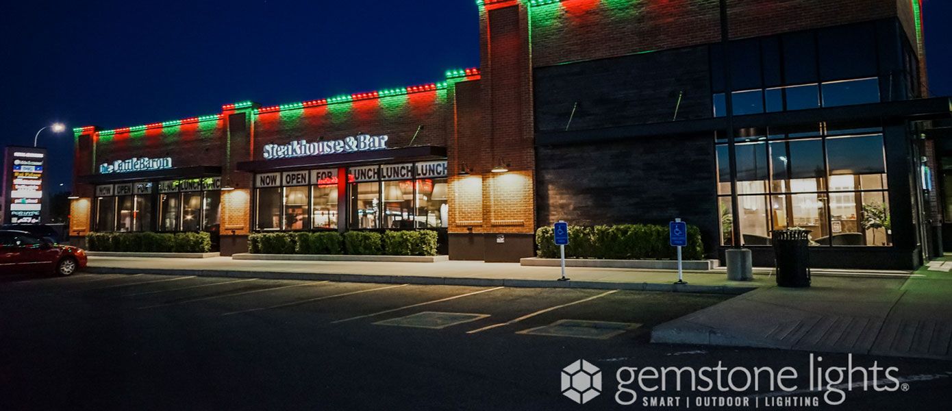 commercial buildings illuminated at night by outdoor lighting
