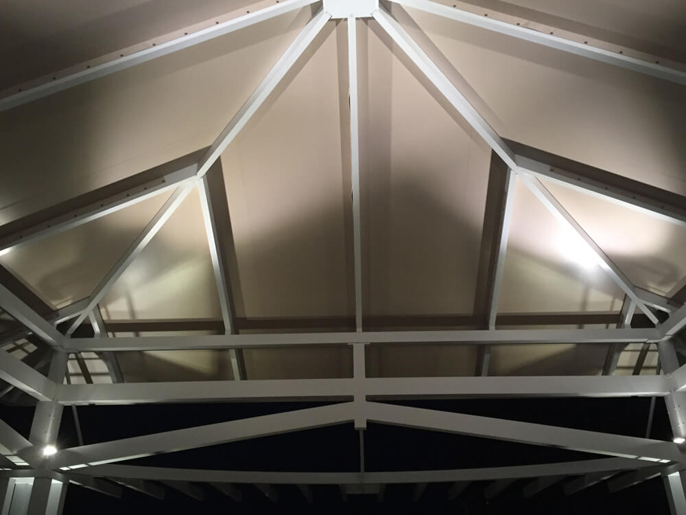 Inside view of the top of a pergola with outdoor lighting