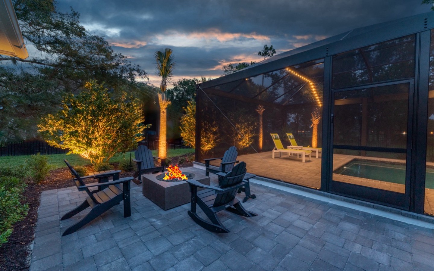 A patio with chairs and a fire pit
Description automatically generated