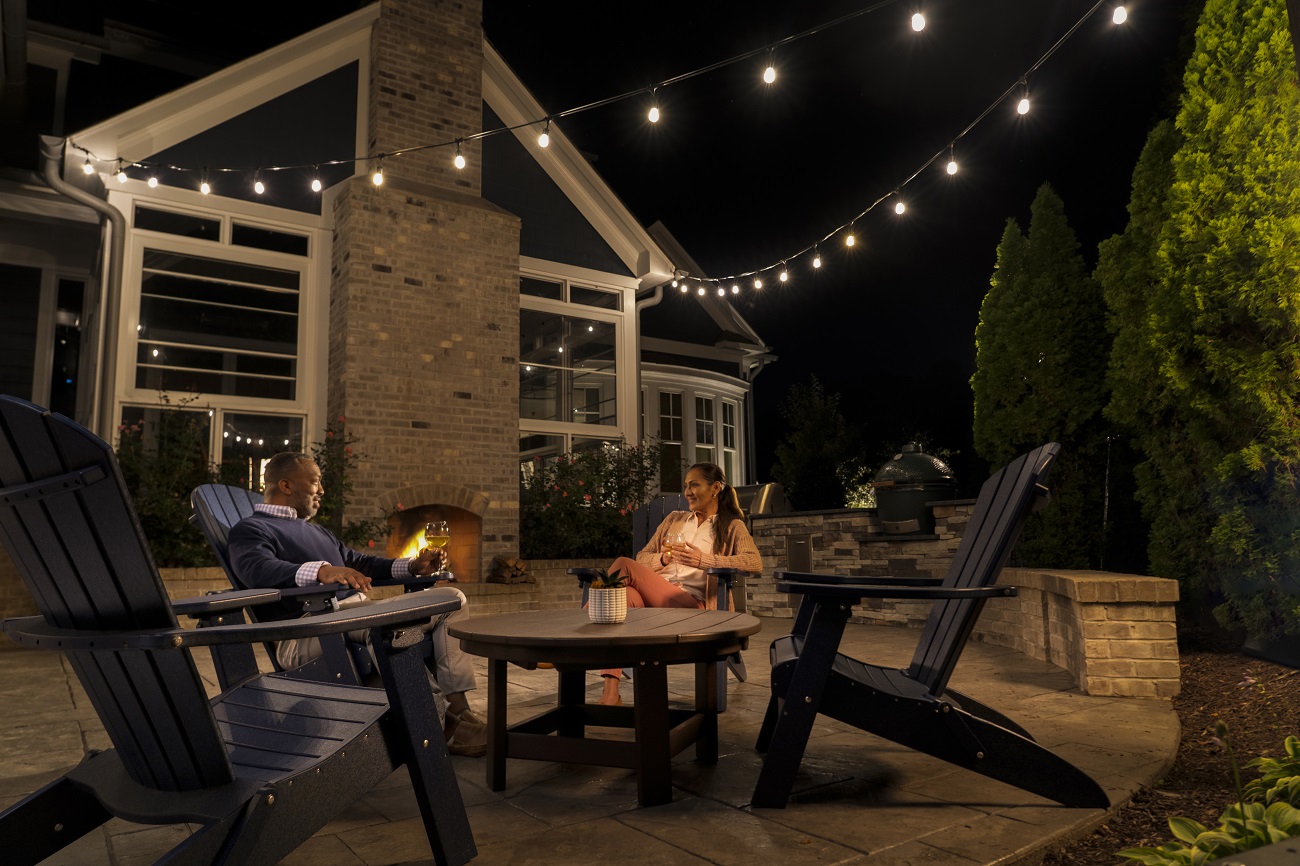 couple sitting by fire on lit patio