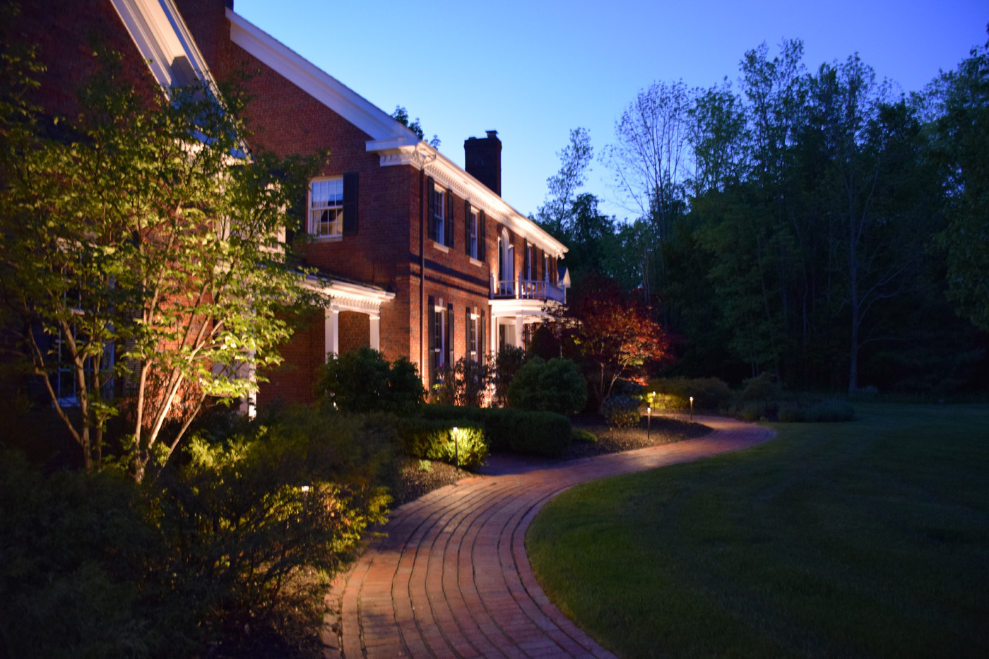 brick home facade with exterior house lights and garden lighting in sammamish