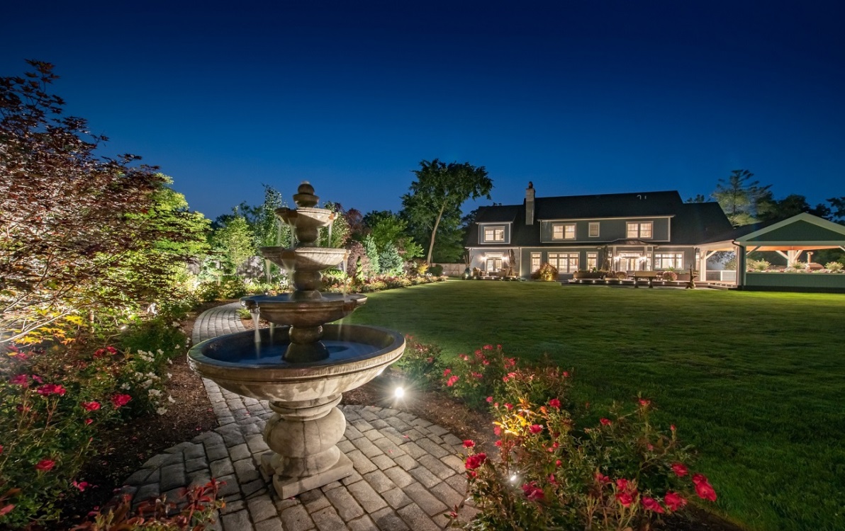 back of house and yard with outdoor lighting