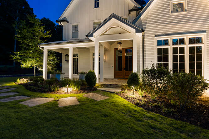 Sandy Springs Outdoor Lighting Enhances White Farmhouse Chic Home with Gorgeous Landscape Lighting and Exterior Home Lighting