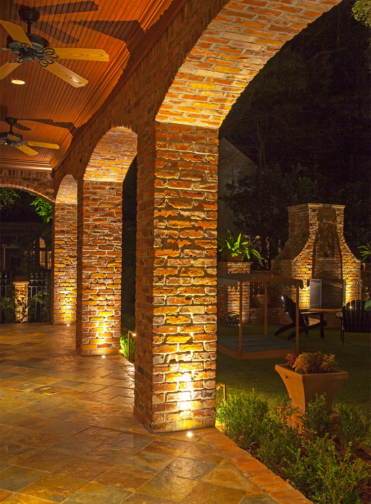 large brick patio area with lighting at night