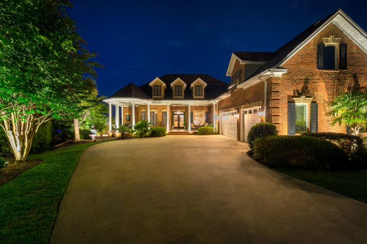brick home with exterior house lighting and landscape lighting in charlotte