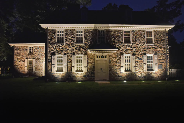 house with stone facade with exterior lighting at night