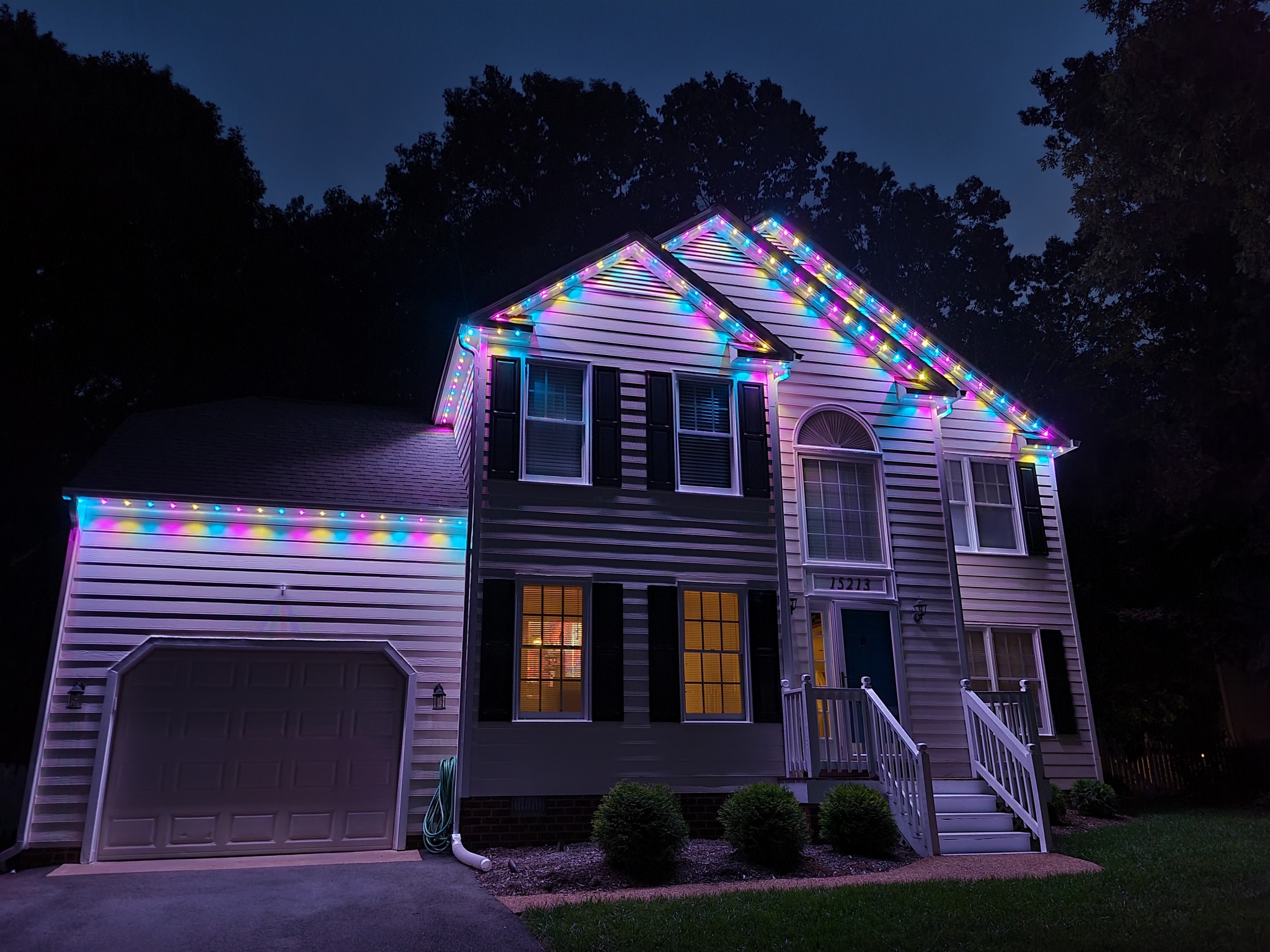 colored permanent roofline lighting on a white house