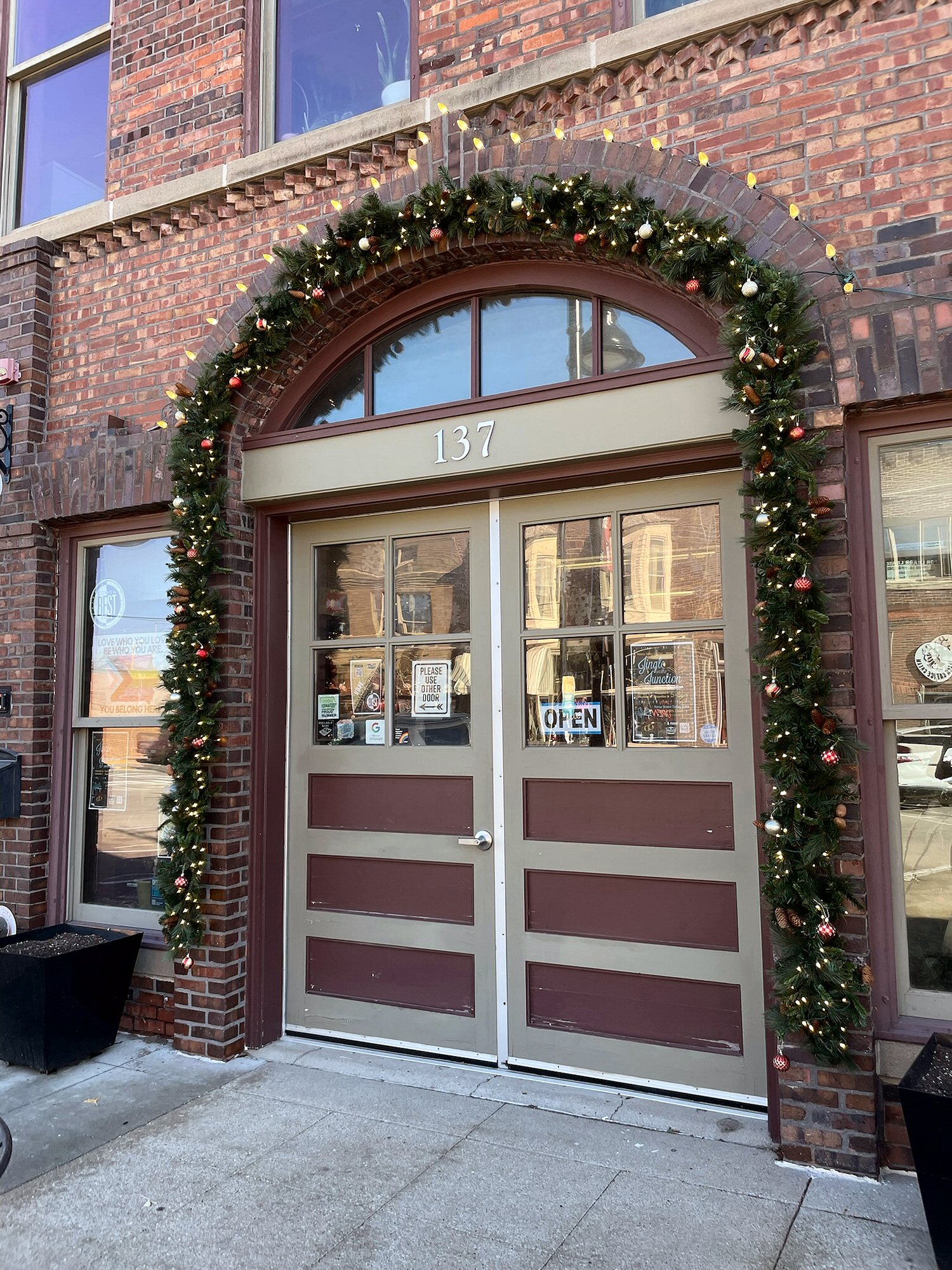 Holiday garland arch decorating the entrance to a commercial property