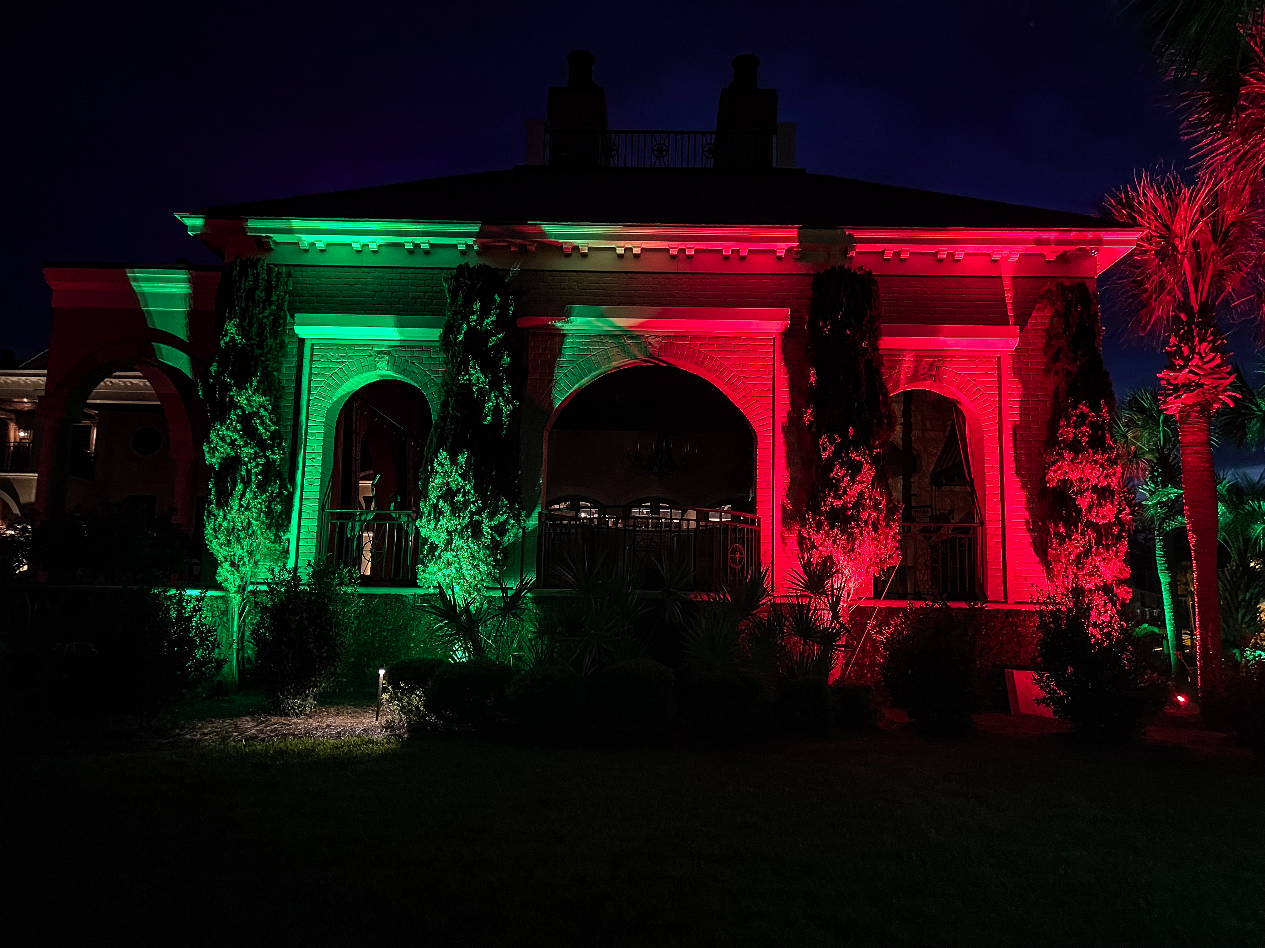 brick arch with green and red holiday lights